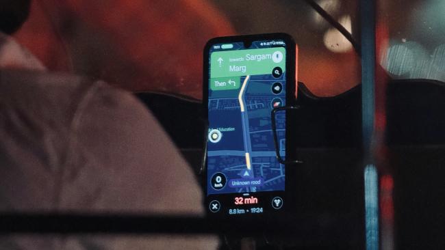 Smartphone s navigační aplikací ve voze