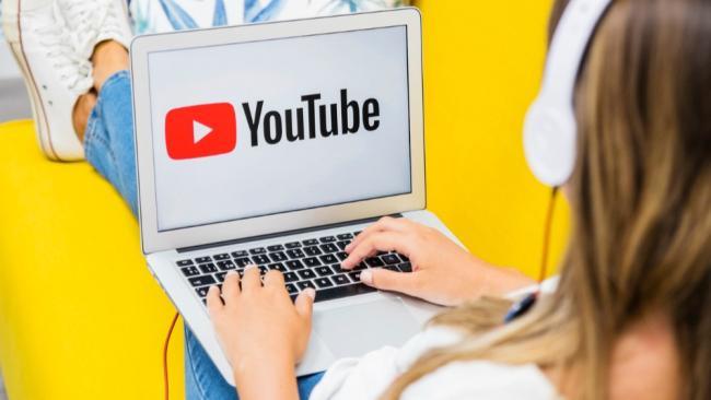 Dívka sleduje YouTube na laptopu