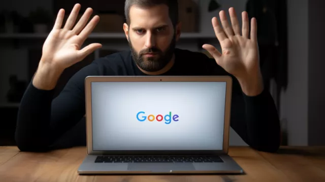 Muž gestikulující stop za displejem laptopu